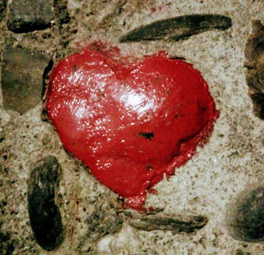 A heart-shaped rock painted in red, found by chance on a street in Granada